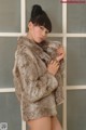 A woman in a fur coat posing for a picture.