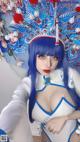 A woman with blue hair wearing a blue and white costume.