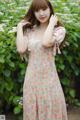 A woman in a floral dress posing for a picture.