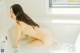 A naked woman sitting in a bathtub with water.