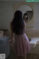 A woman standing in front of a mirror in a bathroom.