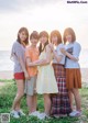 A group of young women standing next to each other on a beach.