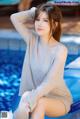 A woman sitting on the edge of a swimming pool.