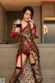 A woman in a leopard print robe holding a glass of wine.