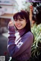 A woman in a purple sweater posing for a picture.