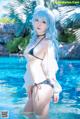 A woman in a bikini standing in a pool.