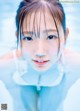 A young girl in a swimming pool looking at the camera.