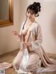 A woman in a pink and white kimono sitting on the floor.