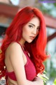 A woman with long red hair posing for a picture.